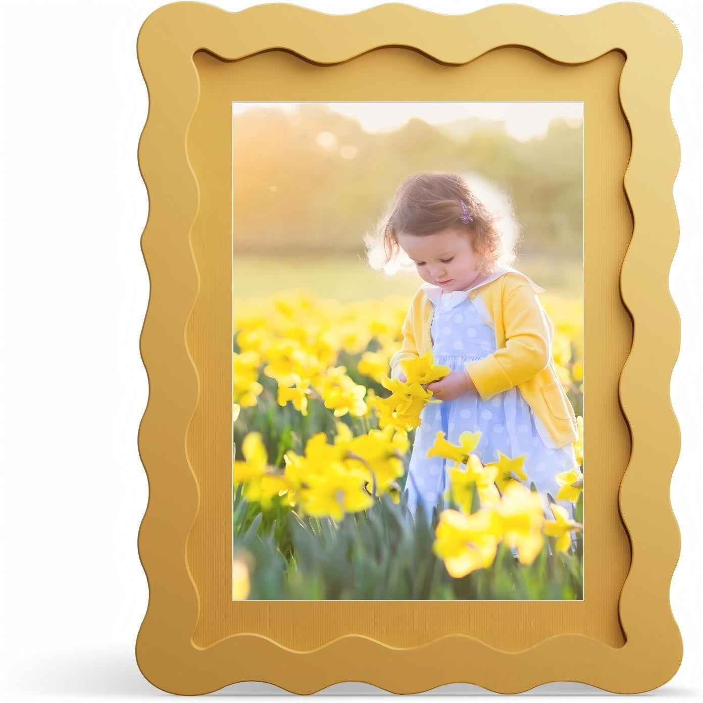 Gold picture frame with a photo of a child in a yellow dress among yellow flowers.